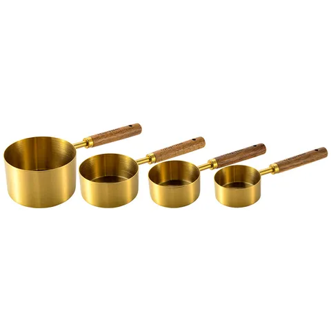 Four gold-tone measuring cups with acacia-wood handles