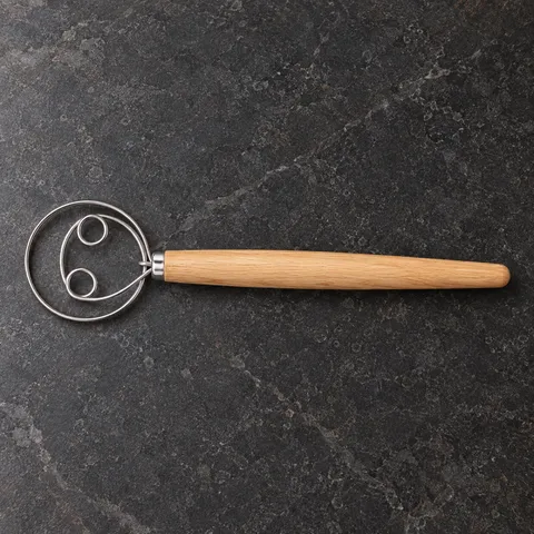 Overhead view of the complete dough whisk on a stone counter